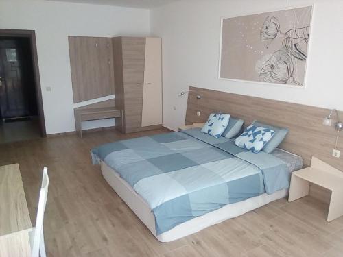 a bedroom with a large bed with blue pillows at Silver Beach A98 in Byala