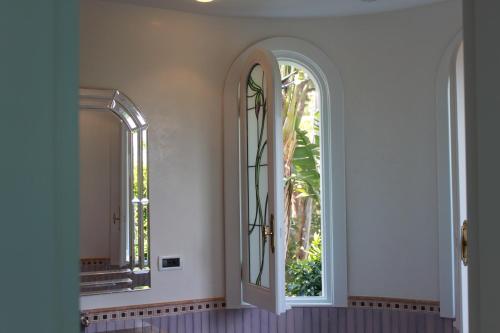 an empty hallway with two windows and a mirror at Villa Marinella in Ischia