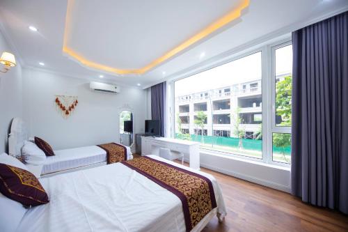 a hotel room with two beds and a large window at Central Hue homestay in Hue