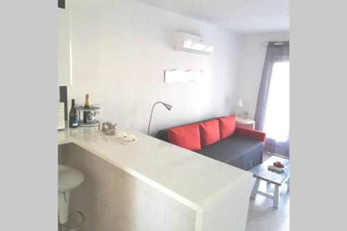 a white kitchen with a couch and red pillows at APARTAMENTOS BINIFORCAT CB apto 52 IDEAL PLACE FOR HOLIDAY in Cala en Blanes