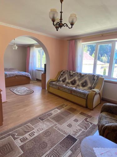a living room with a couch and a bed at Садиба "Джерело" in Yaremche