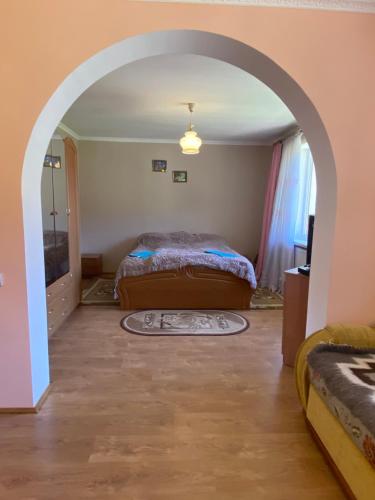 a bedroom with two beds and an archway at Садиба "Джерело" in Yaremche