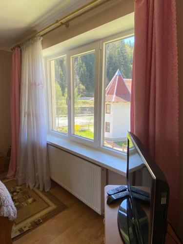 a room with two windows and a desk with a television at Садиба "Джерело" in Yaremche