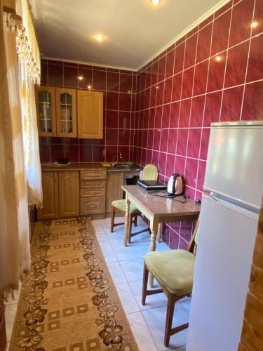 a kitchen with a table and a refrigerator in it at Садиба "Джерело" in Yaremche