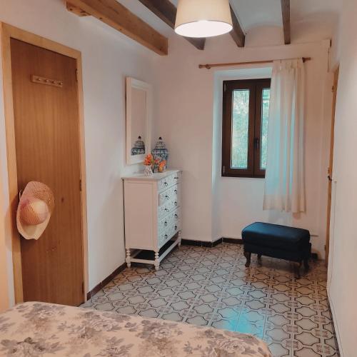 a bedroom with a bed and a dresser and a window at Ca Na Menga in Sóller