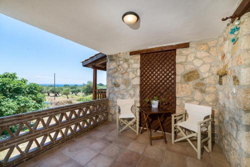 a room with a table and chairs on a balcony at Abeloklima superior apartment in Vasilikos