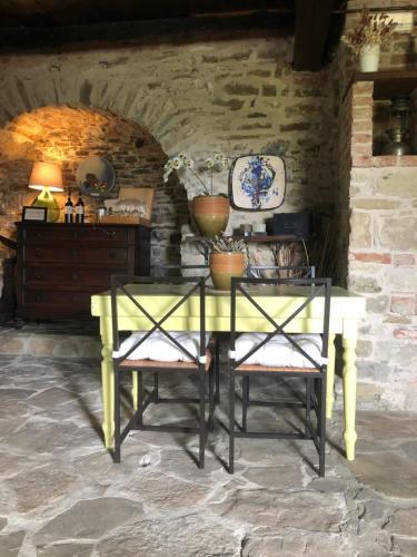 a yellow table and two chairs in a room at Cascina Bertolotto Wine Resort in Spigno Monferrato