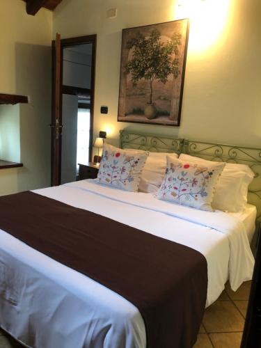 a bedroom with a large bed with white sheets and pillows at Cascina Bertolotto Wine Resort in Spigno Monferrato