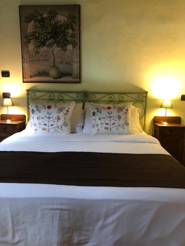a bedroom with a large bed with white sheets and pillows at Cascina Bertolotto Wine Resort in Spigno Monferrato