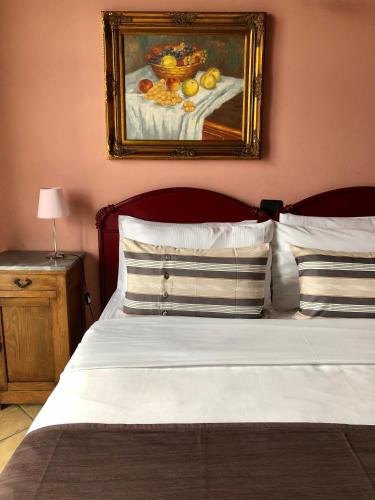 a bedroom with a bed with a painting on the wall at Cascina Bertolotto Wine Resort in Spigno Monferrato