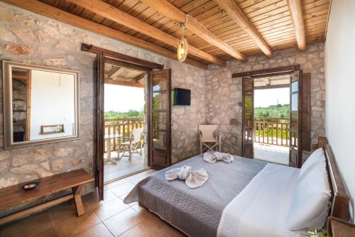 a bedroom with a bed and a balcony at Abeloklima superior apartment in Vasilikos