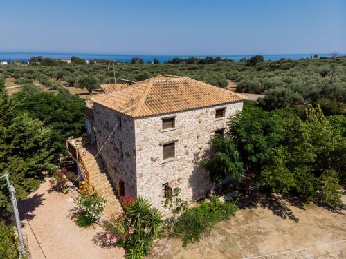 an external view of a stone house with trees at Abeloklima superior apartment in Vasilikos