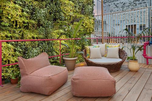 a patio with two chairs and a ottoman on a deck at De Cardo Hotel in Jerusalem