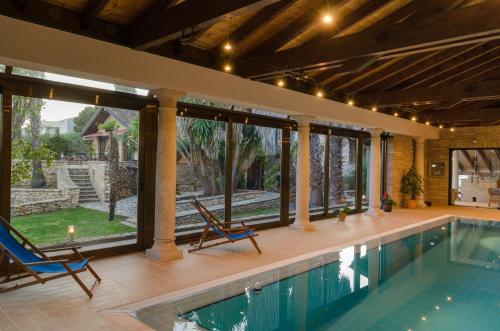 a house with a swimming pool and two chairs at LO CLAUSTRE DEL DELTA- LUX FINCA in Delta del Ebro - FINCA PRIVADA -NO HAY NINGUN SERVICIO HOTELERIA- SOLO ALOJAMIENTO in Sant Carles de la Ràpita