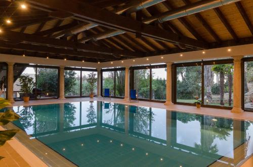 a swimming pool in a house with windows at LO CLAUSTRE DEL DELTA- LUX FINCA in Delta del Ebro - FINCA PRIVADA -NO HAY NINGUN SERVICIO HOTELERIA- SOLO ALOJAMIENTO in Sant Carles de la Ràpita
