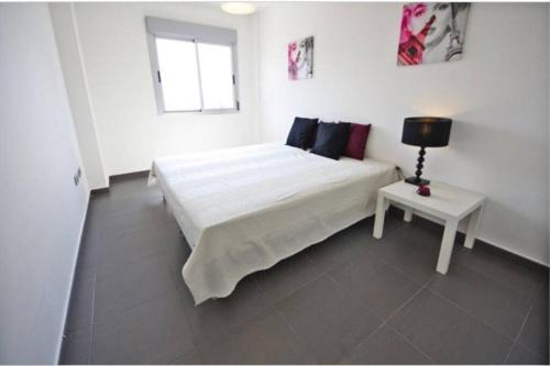 Un dormitorio blanco con una cama grande y una mesa en La Manga Beach Club 04, en San Blas