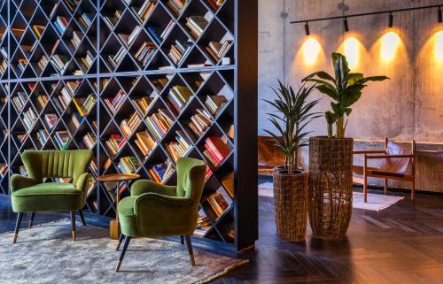 a room with two chairs and a wall of books at Brown Machne Yehuda in Jerusalem