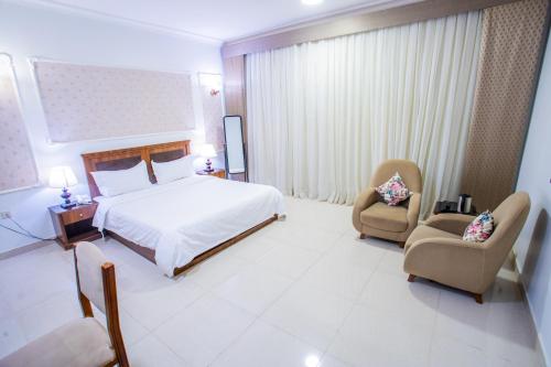 a hotel room with a bed and two chairs at فندق جلنار الراقي للايواء السياحي in Al Madinah