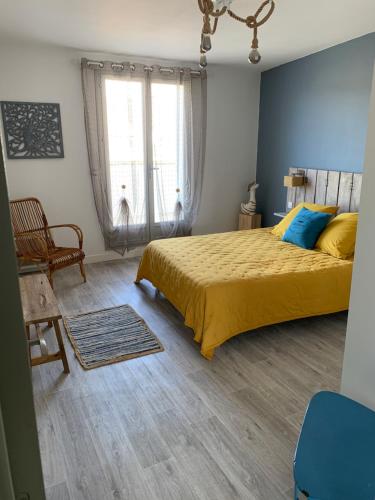 une chambre avec un lit jaune et une fenêtre dans l'établissement Appartement la corde a linge Gruissan village avec terrasses, à Gruissan