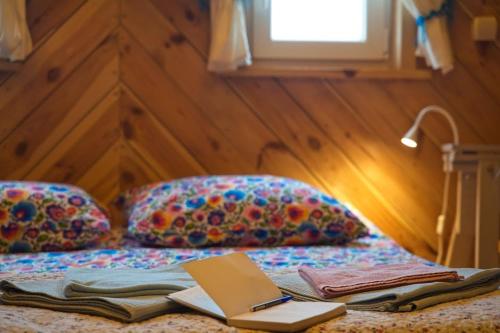 a bed with a book and a laptop on it at Chata Latoś in Tocznabiel