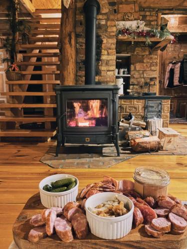 a table with a tray of meat and a fireplace at Chata Latoś in Tocznabiel