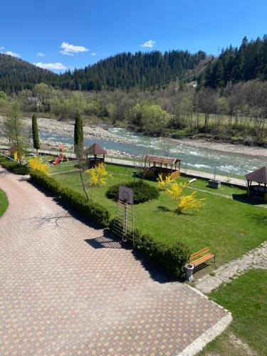 a park next to a river with a park bench at Садиба "Джерело" in Yaremche