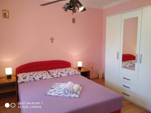 a bedroom with a bed with a purple bedspread at Holiday Home Ružmarin in Velika Čista