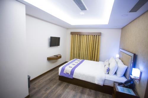 a hotel room with a bed and a window at Hotel 71 in Dhaka