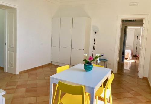 a dining room with a white table and yellow chairs at Antica Dimora Amalfi Coast in Scala