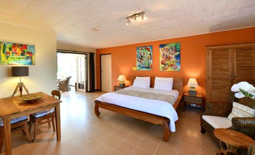 een slaapkamer met een bed, een tafel en een bank bij Wonders Boutique Hotel in Oranjestad