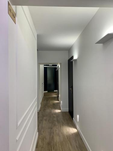 an empty hallway with white walls and wood floors at Toledo Boutique Rooms in Naples