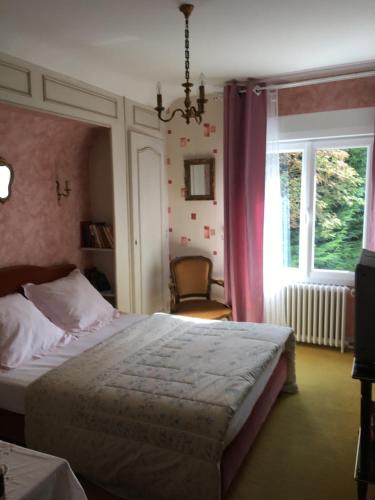 een slaapkamer met een bed en een raam bij Maison Proche de Barfleur accolée à un commerce in Anneville-en-Saire