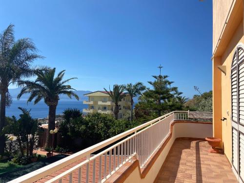 einen Balkon eines Hauses mit Palmen und Meerblick in der Unterkunft Villa Maria in Reggio di Calabria