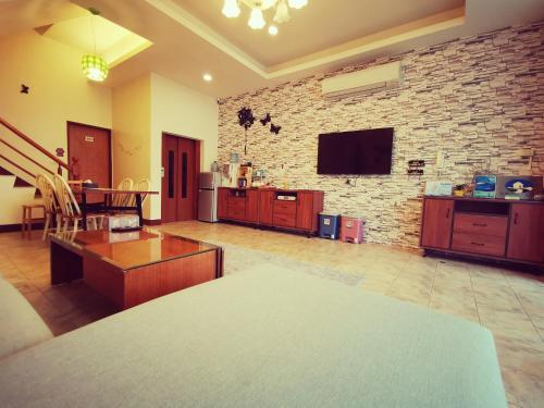 a living room with a brick wall and a tv at Lucky Star B&B in Luodong