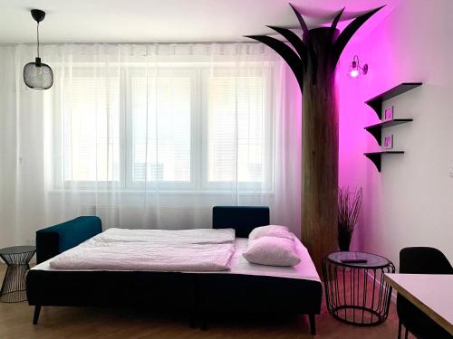 a bedroom with a bed and a palm tree at BeTree in Bratislava