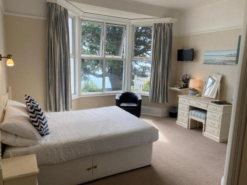 a bedroom with a bed and a desk and a window at The Brunswick in Shanklin