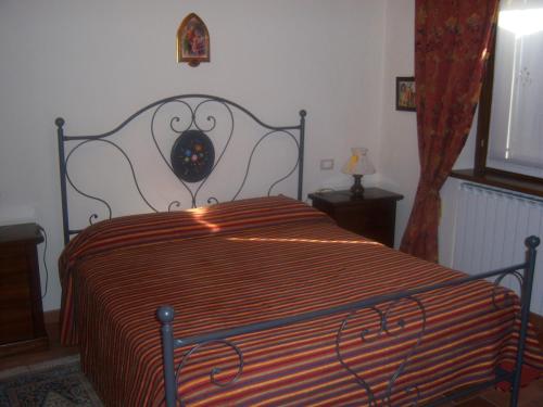 a bedroom with a bed with a striped comforter at Agriturismo Lo Sgorzolo in Pergola