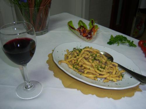 a plate of pasta and a glass of wine on a table at Agriturismo Lo Sgorzolo in Pergola