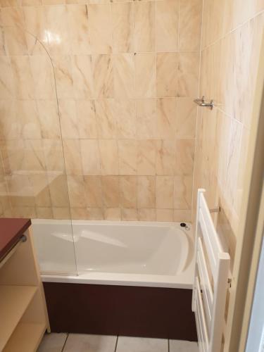 La salle de bains est pourvue d'une baignoire blanche. dans l'établissement Charmante maison avec piscine, à Saint-Cyprien