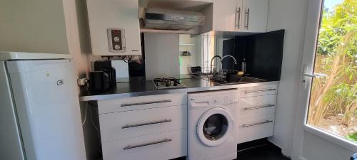 une petite cuisine avec un lave-linge et un lave-linge dans l'établissement Studio avec jardin Fréjus, à Fréjus