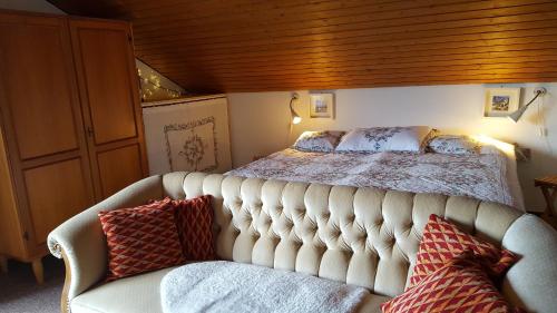 - une chambre avec un lit et un canapé avec des oreillers dans l'établissement Ferienhaus Lucia, App.11, à Schönwald