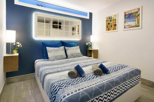 1 dormitorio con 1 cama grande y paredes azules en Ideal Location Beach Flat, en Maspalomas