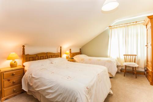 1 dormitorio con 2 camas y ventana en Sunville Bed And Breakfast, en Ballycotton