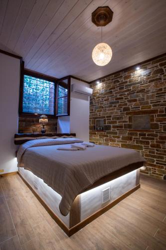 a bedroom with a large bed in a brick wall at The Backyard Fisherman's House in Kato Gatzea