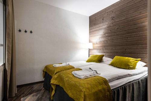 Habitación de hotel con 2 camas con sábanas amarillas en RukaValley Unique46 Ski In - Ski Out en Ruka