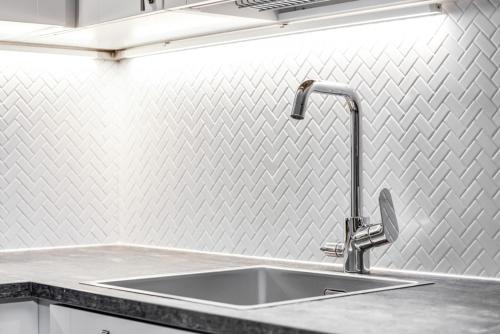 een gootsteen met een kraan aan de muur bij RukaValley Unique46 Ski In - Ski Out in Ruka