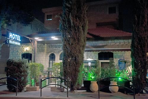 un bâtiment avec un panneau devant lui la nuit dans l'établissement Rothschild Mansion, à Haïfa