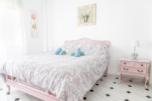a bedroom with a pink bed with blue pillows at Ama in Estepona