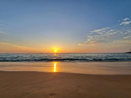 a sunset on a beach with the ocean at The Naithorn Condo Unit 401 in Nai Thon Beach