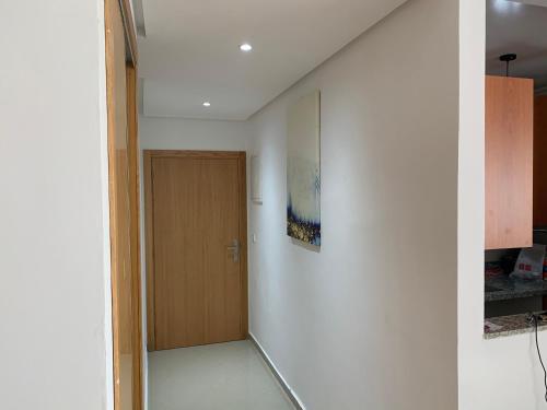 - un couloir avec une porte en bois dans l'établissement Asilah marina golf, à Assilah